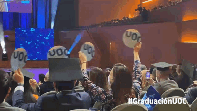 a group of people are holding up uoc balloons