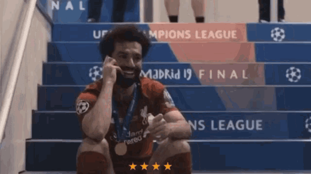a soccer player is sitting on a set of stairs with the word madrid on them