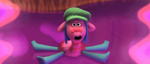 a troll with blue hair and a green hat is smiling