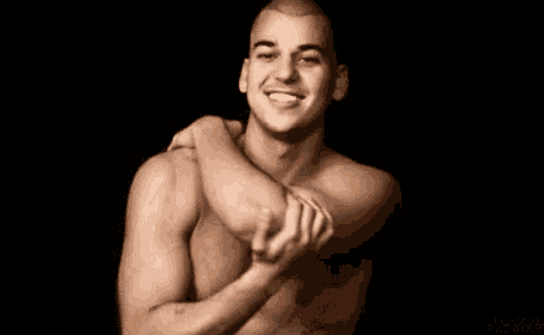 a shirtless man is holding his elbow in his hands .