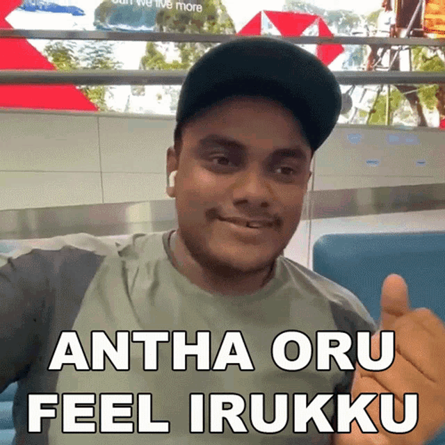 a man wearing a hat giving a thumbs up with the words " antha oru feel irukku " below him