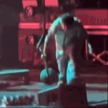 a man is doing a trick on a skateboard while holding a ball .