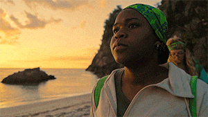 a woman wearing a green headband stands on the beach