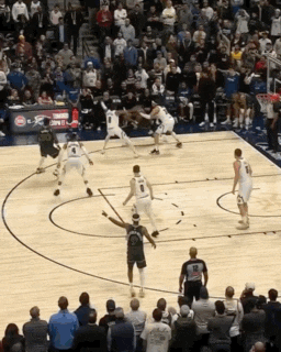 a basketball game is being played in front of a crowd with a sign that says coca cola on it