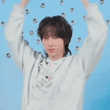 a young man with a mullet is making a funny face with his hands .