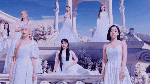 a group of women in white dresses standing in front of a building
