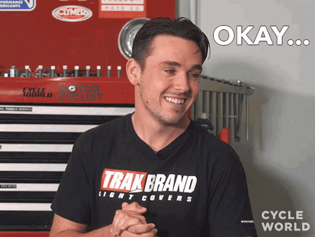 a man wearing a track brand light covers t-shirt is smiling
