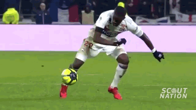 a soccer player with the number 28 on his jersey is kicking a ball