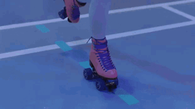 a girl in a pink dress is rollerblading on a court
