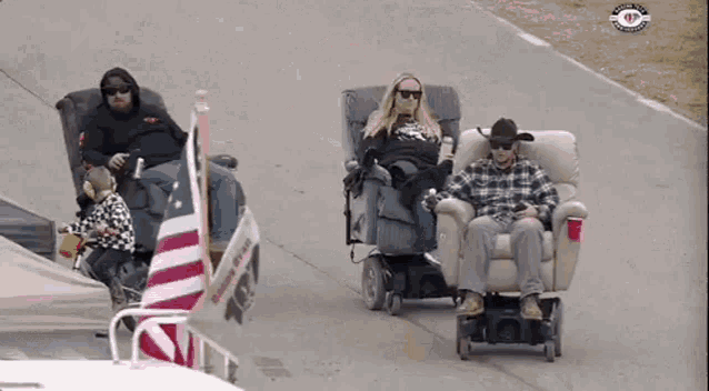 a group of people are sitting in recliner chairs on the street .