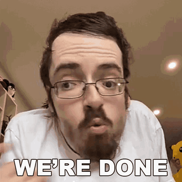 a man with glasses and a beard is making a funny face and says we 're done .