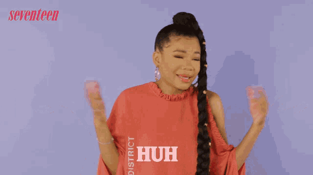 a girl wearing a red shirt that says huh on it