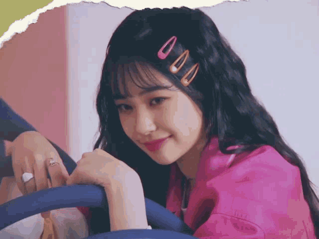 a girl in a pink shirt with hair clips on her head