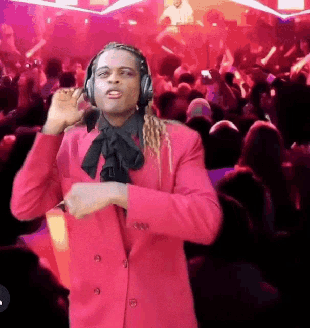 a man in a pink suit is wearing headphones