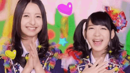 a couple of girls are standing next to each other and smiling .