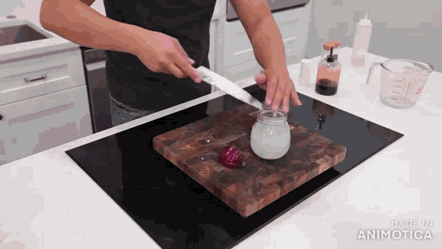 a man is cutting an onion on a wooden cutting board with the words made in animatica behind him