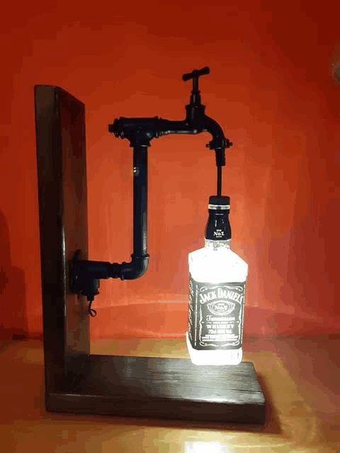 a bottle of jack daniel 's is sitting on a wooden stand