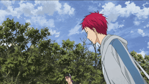 a man with red hair stands in front of a tree