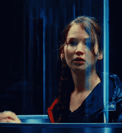 a woman is standing in front of a glass door with her hands outstretched .