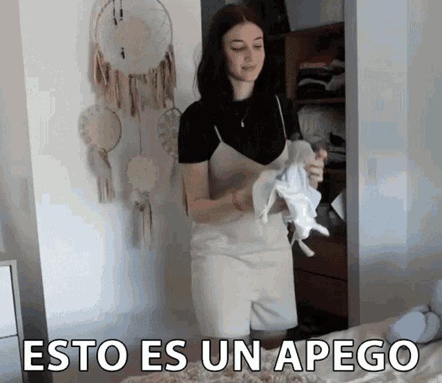a woman in a white dress is standing in front of a closet with the words esto es un apego written on the bottom