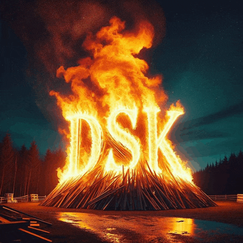 a large pile of wood is burning with the word dsk written in the flames