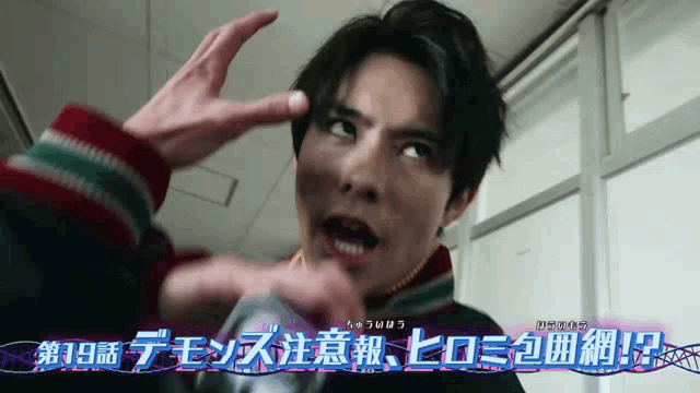 a man is making a funny face in front of a sign that says ' 19 ' on it