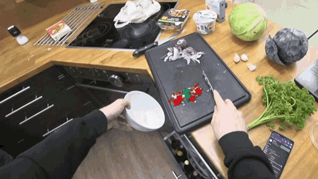 a person is cutting vegetables on a cutting board while a phone displays a song called " everybody "