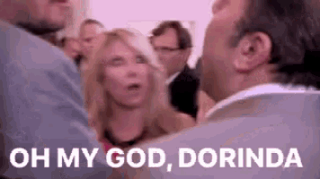 a man and a woman are talking to each other in a crowd and the man is saying `` oh my god dorinda '' .
