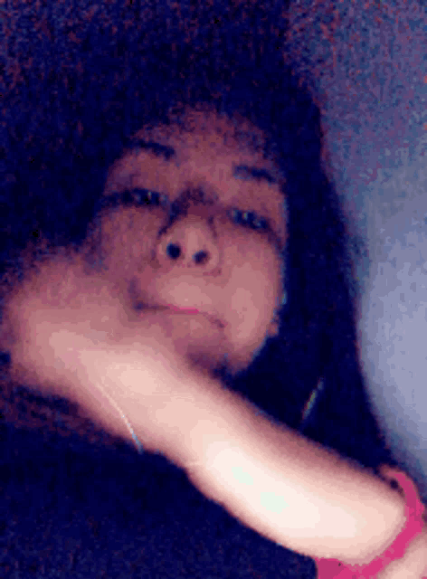 a blurry picture of a woman 's face with her hand on her face .