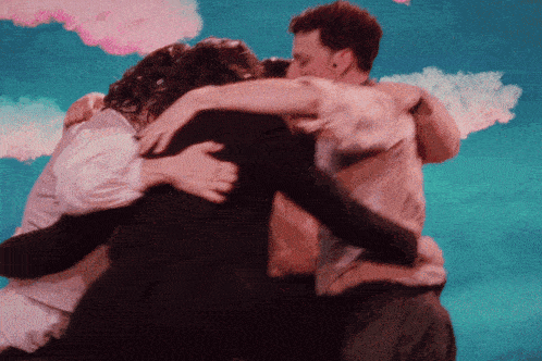 a group of people hugging each other in front of a blue sky