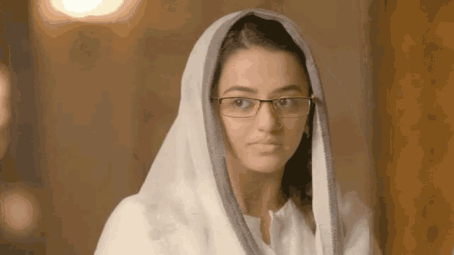 a woman wearing glasses and a white head scarf