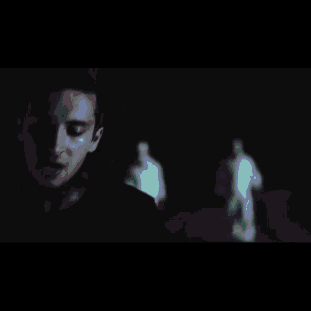 a man wearing a hat is singing into a microphone in a dark room