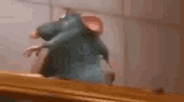 a close up of a cartoon rat standing on top of a table .