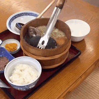 a wooden bucket filled with food is on a table