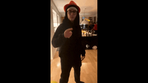 a man in a santa hat is dancing in a room