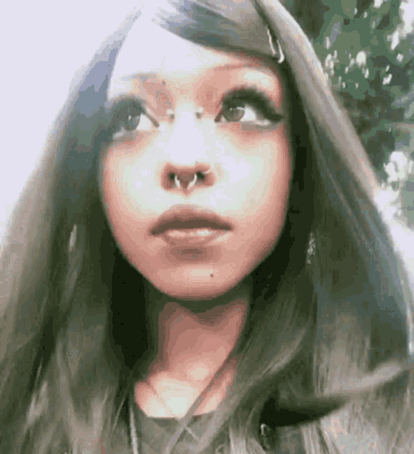 a woman with long hair and a nose ring