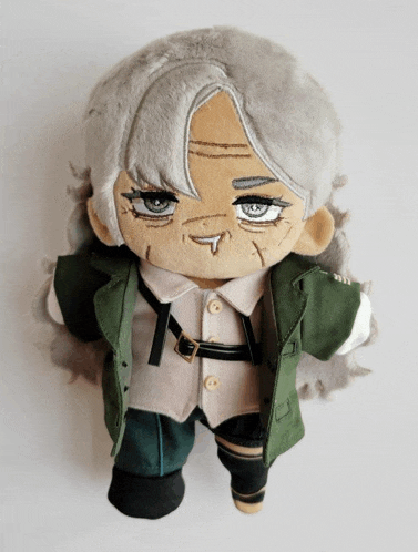 a stuffed doll with gray hair is wearing a green jacket and white shirt