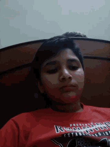 a boy wearing a red shirt that says buffalo bills on the front