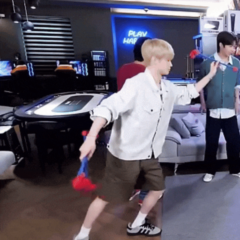 a man is playing a game of badminton in a room with a sign that says play hap