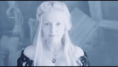 a woman with white hair is wearing a black dress and necklace .