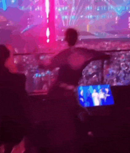a blurry picture of a person in a stadium watching a concert