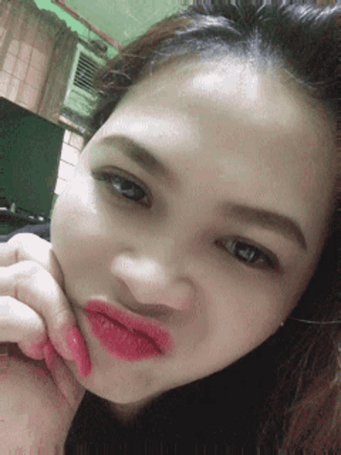 a close up of a woman making a face with her hand