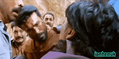 a group of men are standing around a man 's head with a watermark that says iamhemuk