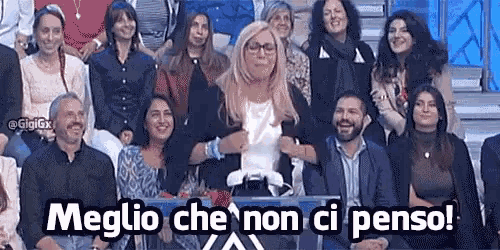 a group of people sitting in front of a sign that says ' meglio che non ci penso '