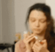 a blurry picture of a woman eating a sandwich
