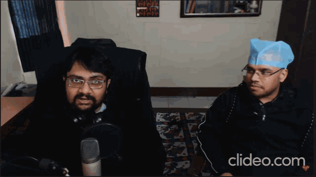two men are sitting in front of a microphone with clideo.com in the bottom right corner