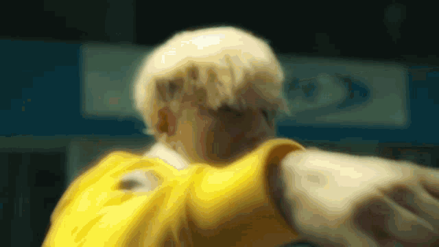 a blurry picture of a man in a yellow shirt pointing