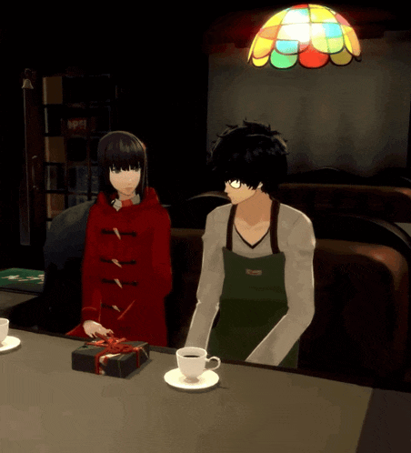 a man in an apron sits next to a woman in a red coat