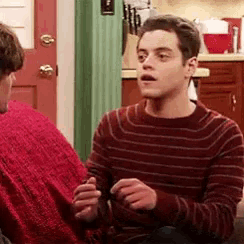 a man in a red striped sweater is talking to another man in a red sweater