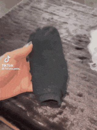 a person is holding a black sock in their hand with tiktok written on it